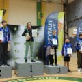 Na zdjęciu zawodnicy HKS Azymut Mochy stojący na podium zajmując 2 i 3 miejsce. Zawodnicy pozują z medalami i dyplomami. Na miejscu pierwszym stoi chłopak z innego klubu sportowego.