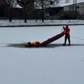 Zdjęcie przedstawia pokazową akcję ratowniczą, która polegała na wyciągnięciu topiącego się z przerębla.