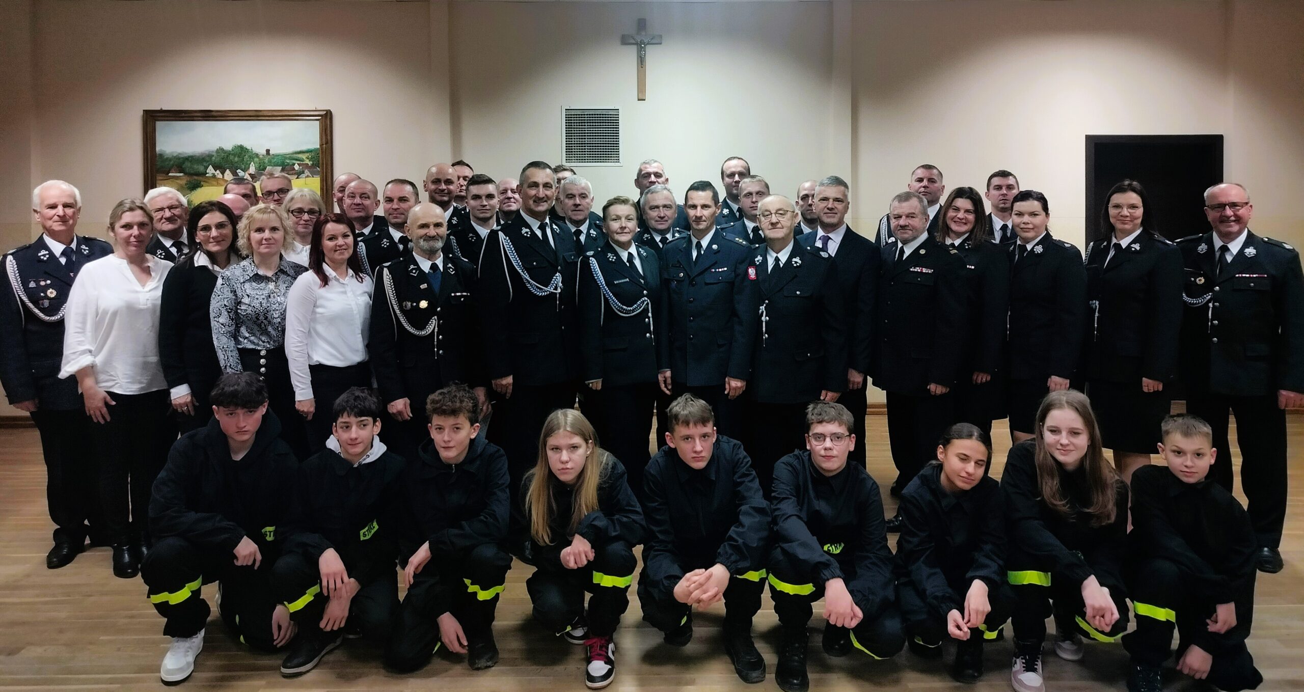 Zdjęcie przedstawia wszystkich strażaków i zaproszonych gości pozujących do zdjęcia.