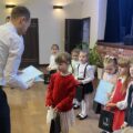 Jury wręcza nagrodę dziewczynce. W tle inne dzieci