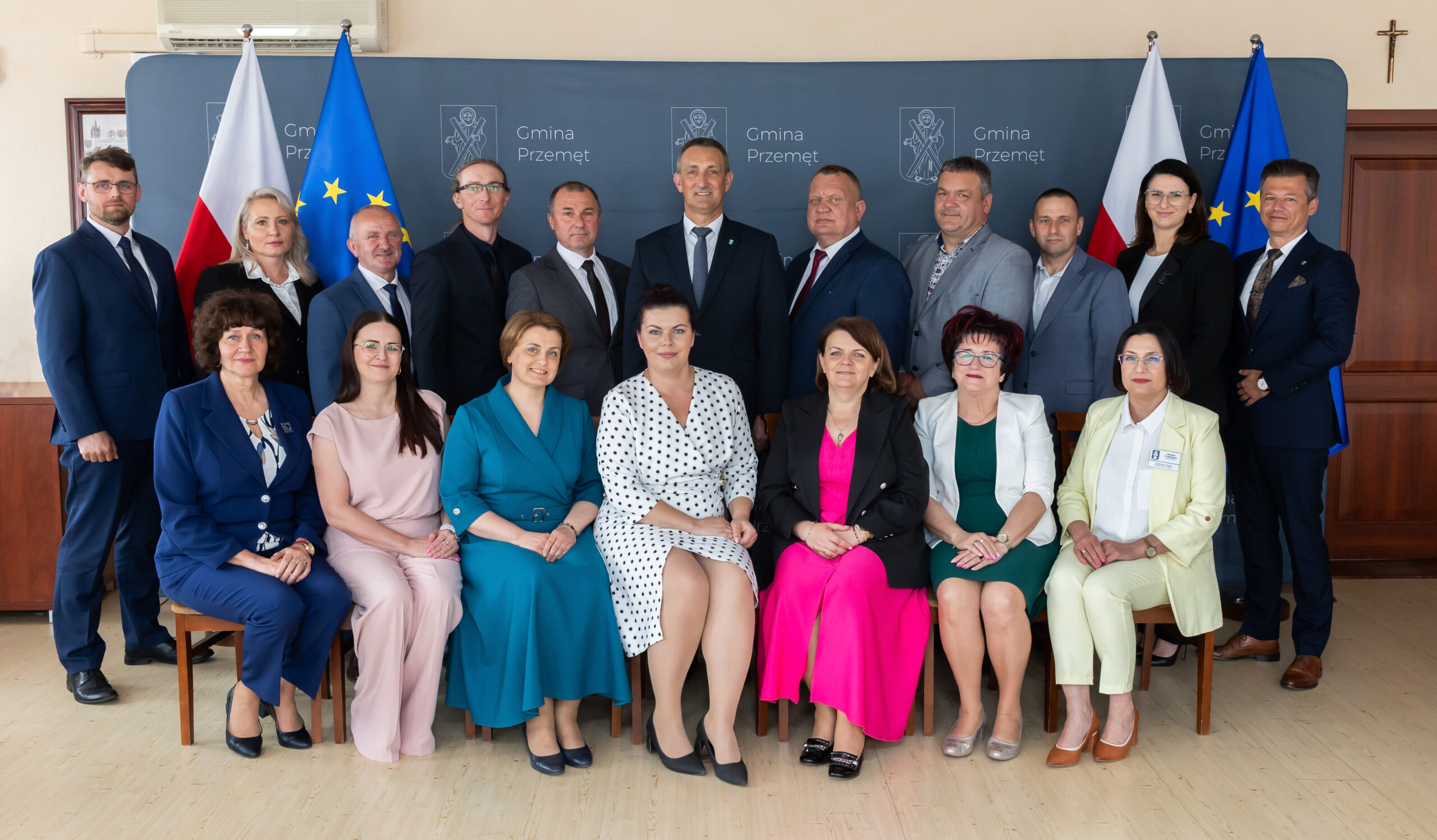 Na zdjęciu pozują wszyscy radni obecnej kadencji wraz z wójtem oraz zastępcą wójta i skarbnikiem. W tle ścianka "Gmina Przemęt" oraz flagi: dwie polski i dwie europejskie.