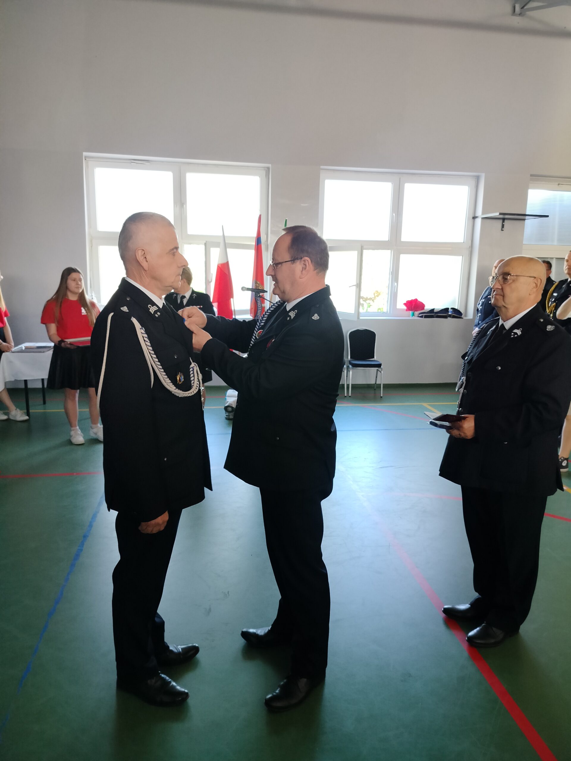 Na zdjęciu dh Henryk Żok przypina dh Marianowi Skibińskiemu odznakę „Semper Vigilant – Wiecznie Czuwający”. W tle dh Józef Pauch.