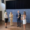 Na zdjęciu wójt, zastępca dyrektora GCKiB oraz trenerki mażoretek VENA Małgorzata oraz Karolina. Trenerki wręczają wójtowi oraz Pani Elwirze puchary.