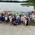 Zdjęcie grupowe uczestników spływu kajakowego. Zdjęcie robione z góry.
