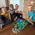 Dzieci pozują do zdjęcia z konstrukcją lego.