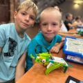 Chłopcy pozują do zdjęcia z konstrukcją lego.