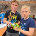 Chłopcy pozują do zdjęcia z konstrukcją lego.
