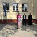Na zdjęciu dyrektor Małgorzata Zielińska podczas przemowy powitalnej na rozpoczęciu roku szkolnego w Mochach. W tle wicedyrektor oraz ksiądz.