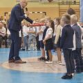 Zdjęcie przedstawia moment pasowania pierwszoklasistów przez dyrektora szkoły w Buczu.