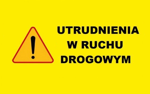 Grafika ma kolor żółty i widnieje na niej znak ostrzegawczy. Koło znaku widnieje napis: "utrudnienia w ruchu drogowym".