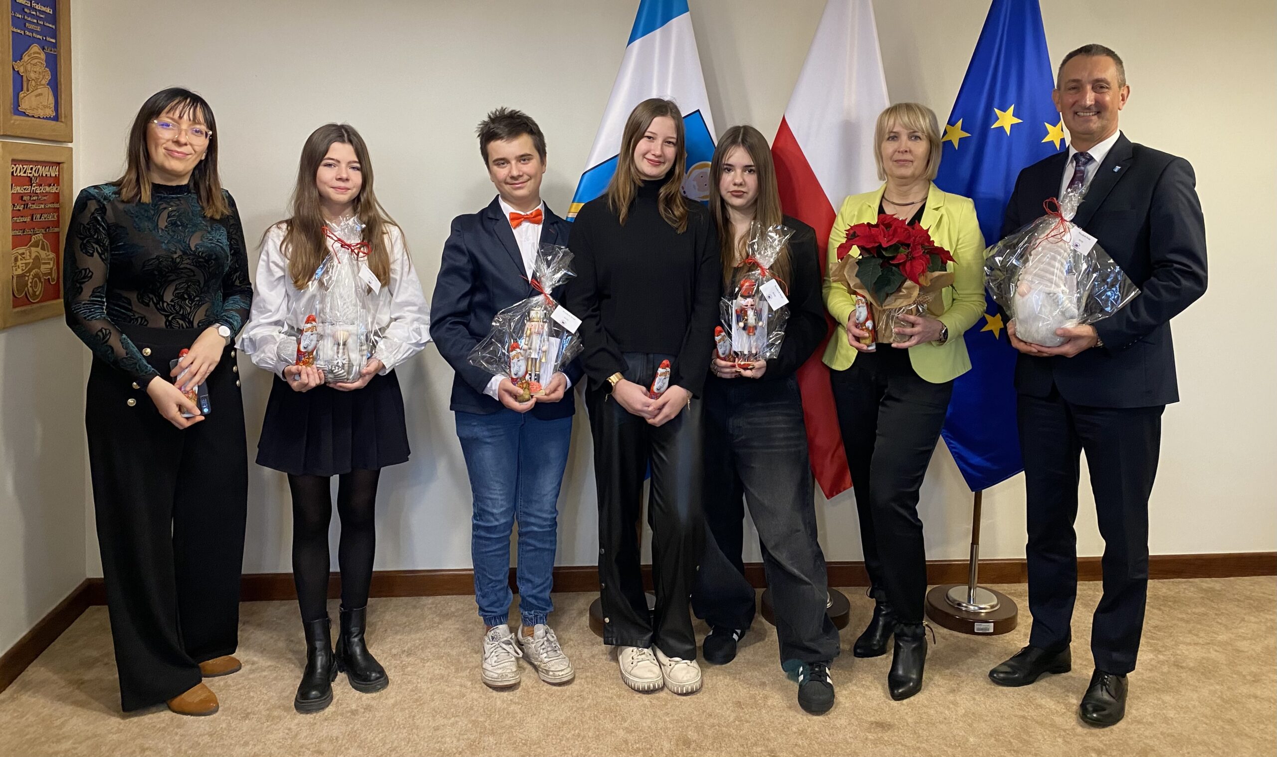 Na zdjęciu wójt, wicedyrektor szkoły ponadpodstawowej w Przemęcie Joanna Kalitka, nauczycielka ze szkoły oraz czwórka uczniów. Każda z osób pozuje z jakimś upominkiem świątecznym.