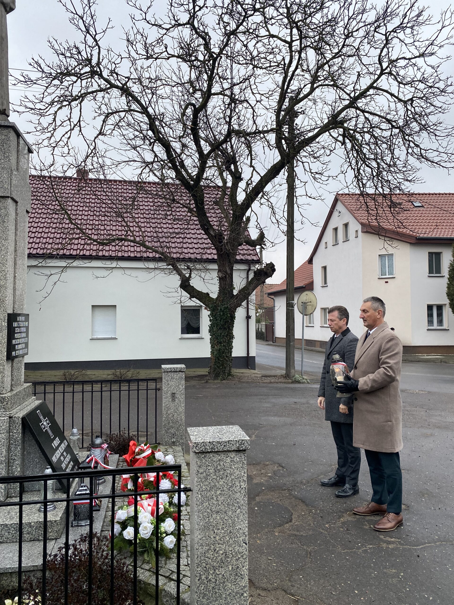 Na zdjęciu wójt gminy Przemęt oraz zastępca wójta oddają hołd bohaterom Powstania Wielkopolskiego pod pomnikiem na rynku przemęckim. Wójt trzyma zapalony znicz.