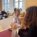 Dziewczynka odbiera nagrodę od pani dyrektor.