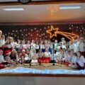 Wspólne zdjęcie artystów na scenie w Kluczewie. Scena udekorowana jest w świecącą betlejemską gwiazdę.