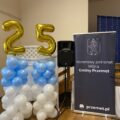 Na zdjęciu roll up honorowy patronat wójta gminy Przemęt oraz ścianka zrobiona z białych i niebieskich balonów oraz złotych balonów liczba 25.
