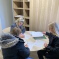 Na zdjęciu trzy osoby - dwie pracownice urzędu oraz wykonawca i kierownik budowy. Wyżej wymienione osoby podpisują protokoły w pomieszczeniu biurowym.