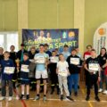 Zdjęcie grupowe chłopców. Każdy chłopak pozuje z dyplomem, a zwycięzcy z dyplomami, pucharami i upominkami. Na fotografii także Wiceprezes Zarządu Oddziału Gminnego ZOSP RP w Przemęcie dh Marian Skibiński, Pani Julita Nitschke oraz dwie inne kobiety. W tle baner "Gmina Przemęt wspiera sport".