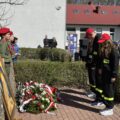 Na fotografii delegacja złożona z młodzieży z OSP. Wyżej wymienieni składają wiązankę przed tablicą "Dąb Pamięci".