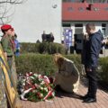 Na zdjęciu jedna z delegacji składa wiązankę przed tablicą "Dąb Pamięci".