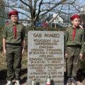 Na zdjęciu dwójka harcerzy stoi koło tablicy "Dąb Pamięci".