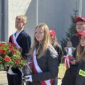 Na fotografii delegacja złożona z uczniów szkoły. Trzymają wiązankę oraz znicz.