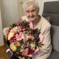 Na zdjęciu Pani Irena Ziarkowska z dużym bukietem kwiatów.