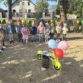 Na zdjęciu widoczny jeden z elementów placu zabaw ozdobiony balonami. W tle dzieci.