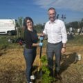 Na zdjęciu wójt gminy oraz dyrektorka Radomierza - Patrycja Kmieciak. Wyżej wymienione osoby pozują do zdjęcia przy nowo zasadzonym drzewku i wspólnie trzymają łopatę.