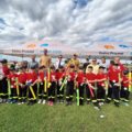 Grupowe zdjęcie jednej z drużyn. Dzieci pozują do zdjęcia z medalami i nagrodami. Na fotografii także organizatorzy i niektórzy zaproszeni goście.