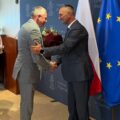 Na fotografii prezes Józef Kwaśniewicz wręcza wójtowi bukiet kwiatów.