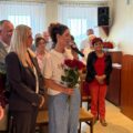 Na fotografii p.o. dyrektora Agnieszka Klugiewicz wraz ze swoją zastępczynią Elwirą Michalewicz składa życzenia wójtowi. W tle widoczne są inne osoby obecne na sesji.