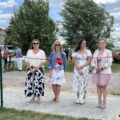 Na zdjęciu 4 kobiety, wśród nich sołtys Bucza Izabela Franek oraz radna gminy Anna Barczyńska. Wszystkie kobiety stoją przed czerwoną wstążką zawiązaną na kokardkę, rozpiętą między dwoma słupkami.