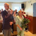 Na fotografii widoczny jest dyrektor szkoły z Bucza, który wraz z dyrektorką przedszkola z Nowej Wsi składają życzenia wójtowi. W tle inne osoby obecne na uroczystości.