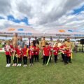 Grupowe zdjęcie jednej z drużyn. Dzieci pozują do zdjęcia z medalami i nagrodami. Na fotografii także organizatorzy i niektórzy zaproszeni goście.