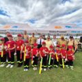 Grupowe zdjęcie jednej z drużyn. Dzieci pozują do zdjęcia z medalami i nagrodami. Na fotografii także organizatorzy i niektórzy zaproszeni goście.