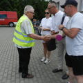 Na fotografii wójt wraz z sołtysem i panią Elwirą wręczają jednemu z uczestników rajdu upominek i medal.