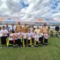 Grupowe zdjęcie jednej z drużyn. Dzieci pozują do zdjęcia z medalami i nagrodami. Na fotografii także organizatorzy i niektórzy zaproszeni goście.