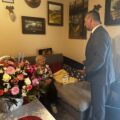 Na fotografii wójt, który odczytuje list gratulacyjny pani Stefanii. Na zdjęciu widoczny także duży kosz kwiatów.