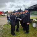Na fotografii ukazano moment przypinania medali i składania gratulacji strażakom.