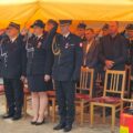 Na fotografii widoczni m.in. komendant powiatowy PSP w Wolsztynie – kpt. Damian Glapiak, przewodnicząca rady Monika Maćkowiak, prezes Zarządu Oddziału Gminnego ZOSP RP w Przemęcie dh Józef Pauch oraz inne osoby obecne na uroczystości. Wyżej wymienione osoby wykonują salut.