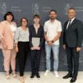 Na zdjęciu wójt, absolwent szkoły podstawowej, który pozuje z listem gratulacyjnym oraz wicedyrektor szkoły ze Starkowa. W tle ścianka gminy.