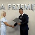 Na fotografii wójt wręcza akt mianowania jednej z nauczycielek. W tle srebrny napis "Przemęt".