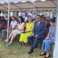 Na zdjęciu widać ludzi siedzących pod namiotem, m.in. wójta gminy i panią sołtys Perkowa. W tle widoczne są grupy rozmawiających ludzi.