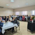 Na fotografii uczestnicy warsztatów siedzą przy stołach.