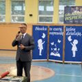 Na fotografii wójt Janusz Frąckowiak przemawia podczas rozpoczęcia roku szkolnego w Buczu na sali gimnastycznej. W tle dekoracja z napisem: "Nauka to czary, które naprawdę działają".