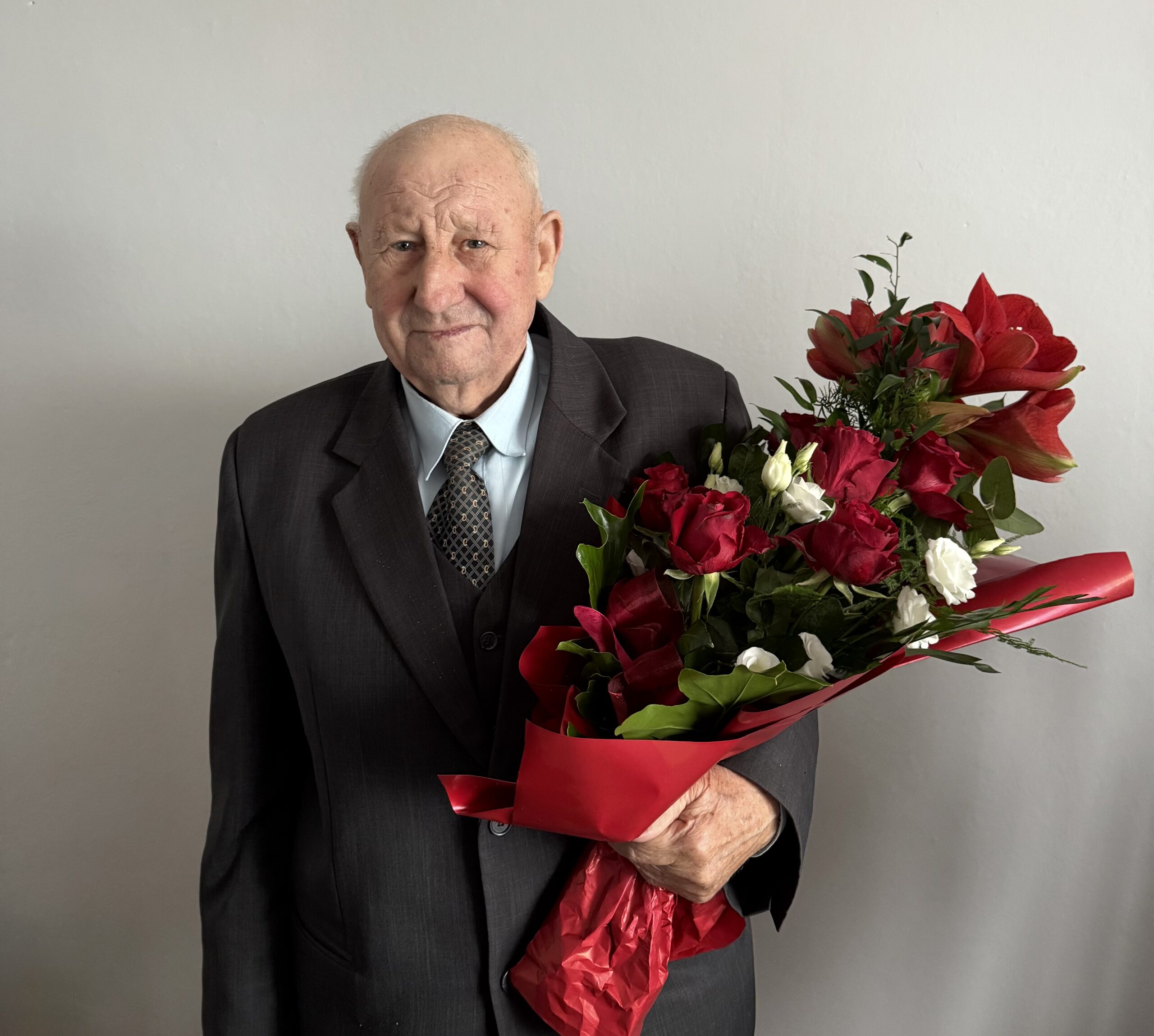 Na fotografii jubilat z bukietem kwiatów.