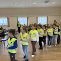 Na zdjęciu uczniowie ubrani w kamizelki odblaskowe.