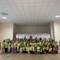 Grupowe zdjęcie uczniów z osobami obecnymi na spotkaniu w szkole w Starkowie.