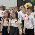 Zdjęcie przedstawia występ artystyczny trójki uczniów.