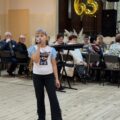 Na zdjęciu widoczna dziewczynka podczas śpiewania na uroczystości.